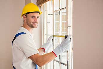 cheap double glazing installed by man in yellow hat